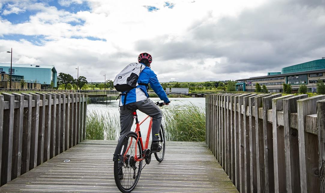 Man on bike overlooking Inverness Campus lochan