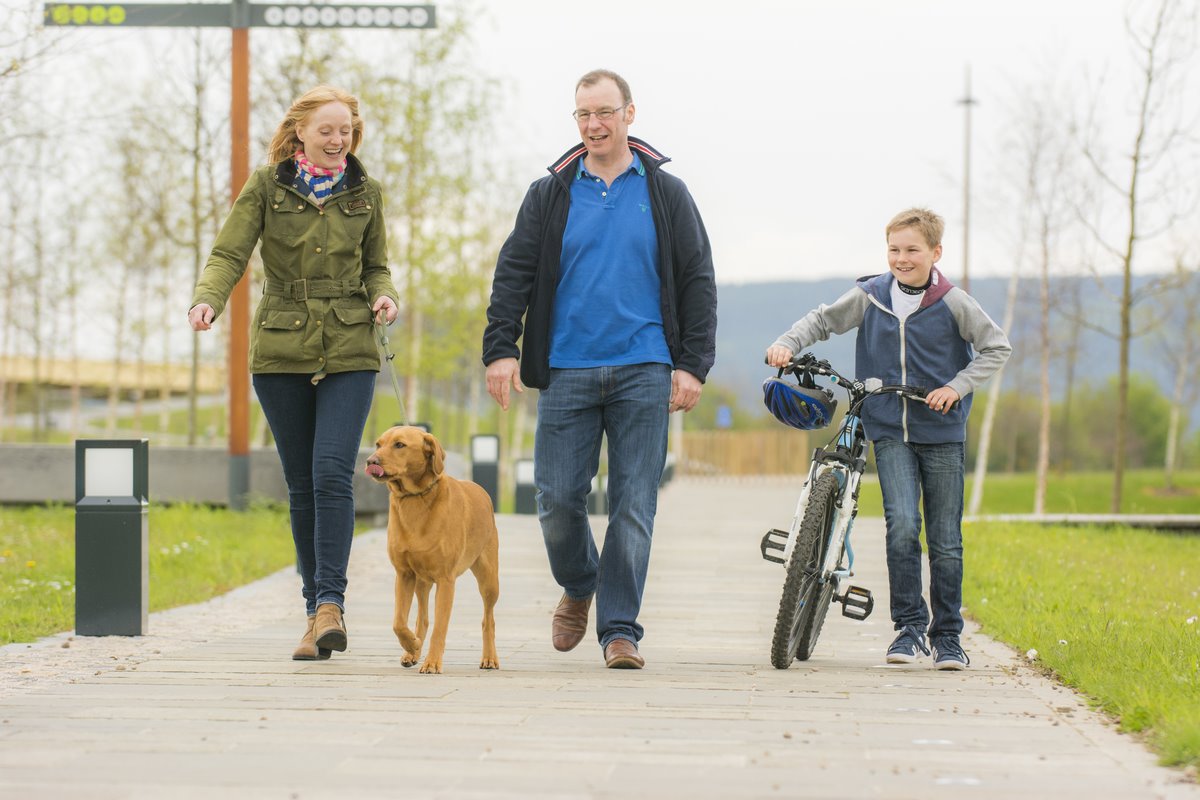 Family with dog walking around Inverness Campus grounds