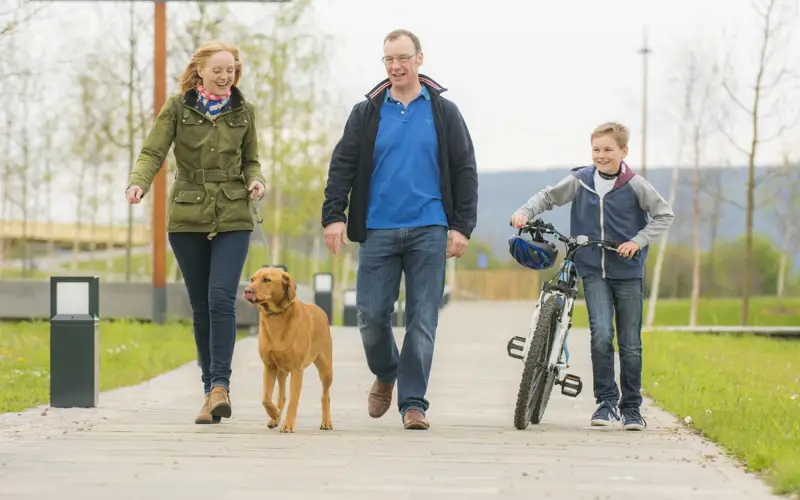 Family with dog walking around Inverness Campus grounds