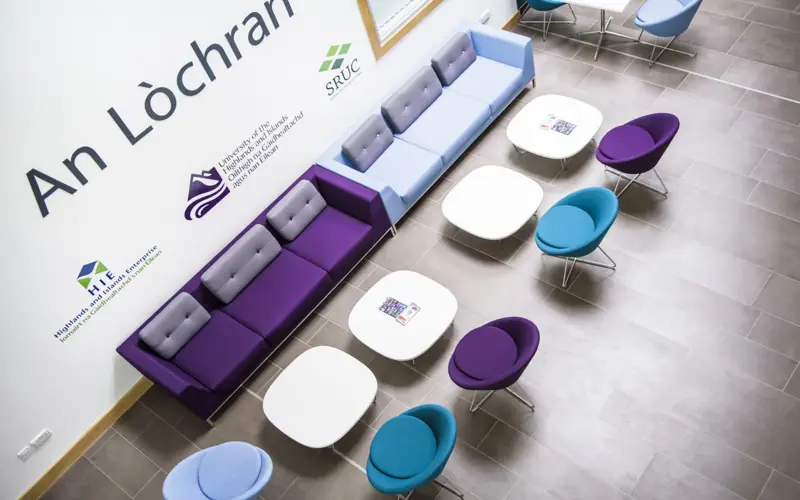 View from balcony looking down on tables and chairs in An Lochran, HIE's headquarters in Inverness
